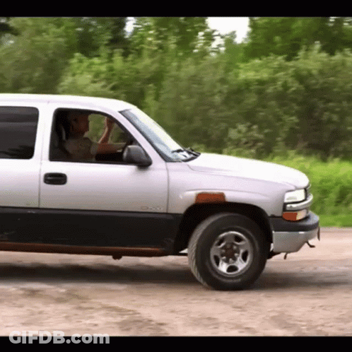 Man Driving Silver GMC Truck GIF