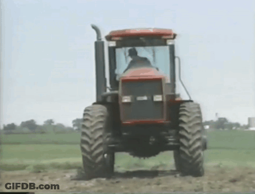 Man Driving Tractor Through Field GIF
