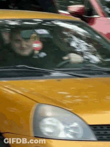 Man Driving Yellow Car With Red And White Sign GIF