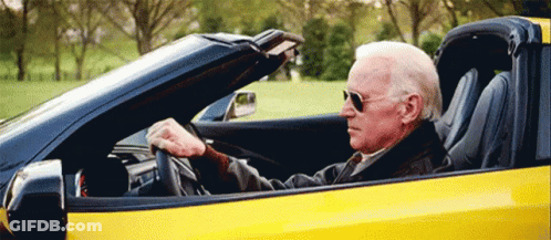 Man Driving Yellow Sports Car Top Down GIF