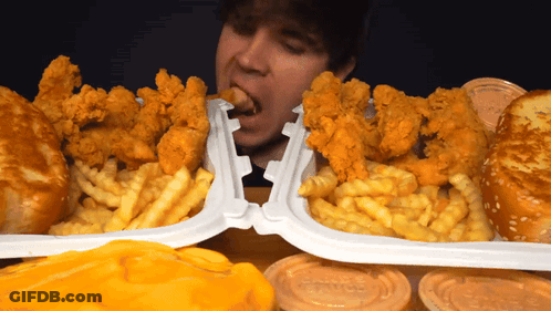 Man Eating Chicken And Fries In Plastic Containers GIF