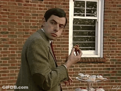 Man Eating Doughnut In Front Of Brick Wall GIF