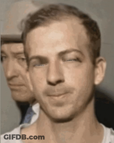 Man Eating Food In Front Of Red Ta Sign GIF
