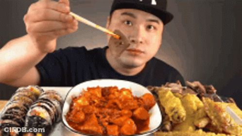 Man Eating Food With Chopsticks In NY Hat GIF