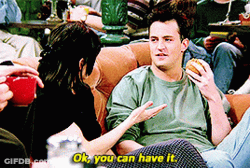 Man Eating Hamburger On Couch Talking To Woman Saying Ok You Can Have It GIF