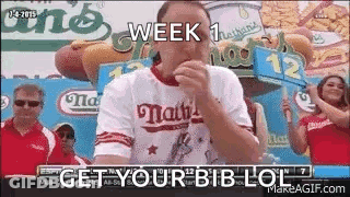 Man Eating Hot Dog With Get Your Bib Lol Sign GIF