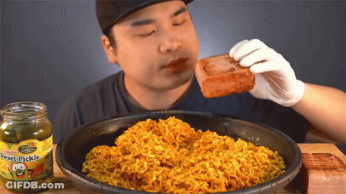 Man Eating Meat Next To Jar Of Hot Pickle GIF