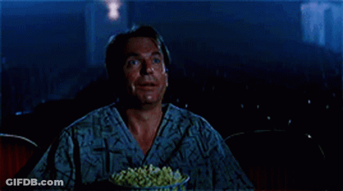 Man Eating Popcorn And Smiling In Theater GIF