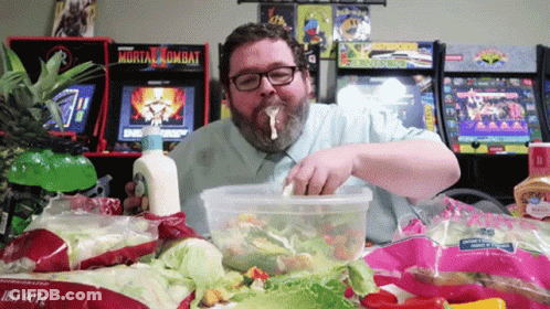 Man Eating Salad In Front Of Mortal Kombat Machine GIF