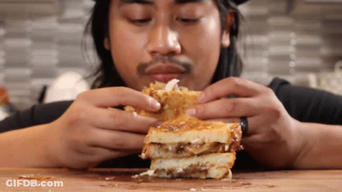 Man Eating Sandwich With Toppings GIF