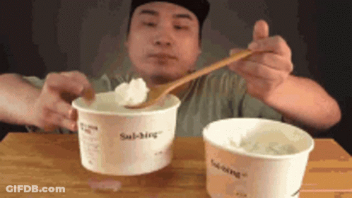 Man Eating Two Cups Ice Cream With Wooden Spoon GIF