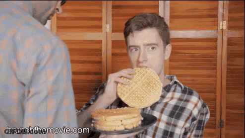 Man Eating Waffle While Another Holds Pancakes GIF