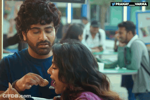 Man Feeding Woman Food With Pranay_varma Logo GIF