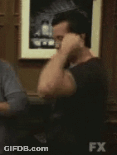 Man Flexing Muscles In Front Of FX Sign GIF