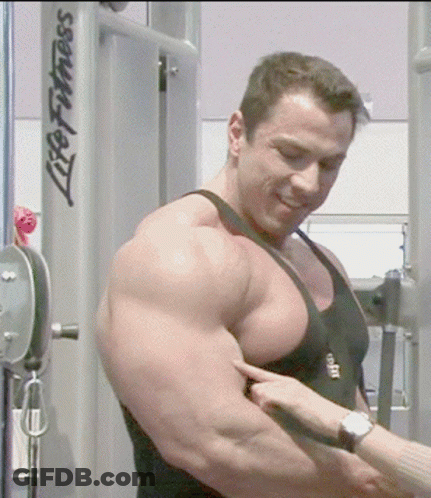 Man Flexing Muscles In Front Of Life Fitness Machine GIF