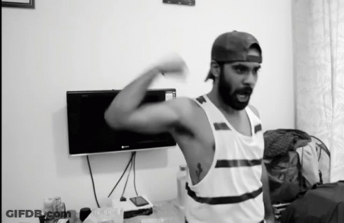Man Flexing Muscles In Front Of TV GIF