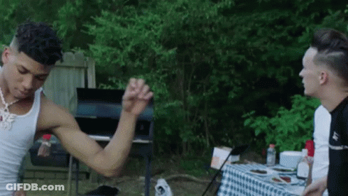 Man Flexing Muscles Next To Checkered Table GIF