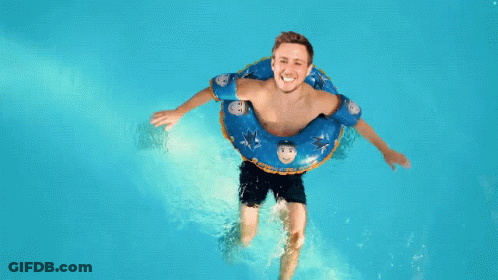 Man Floating In Pool With Blue Shark Tube GIF