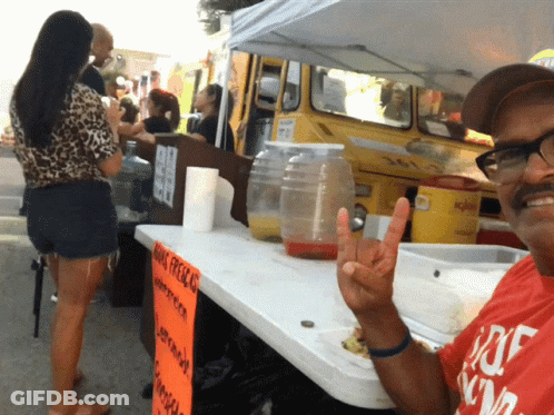Man Giving Peace Sign In Front Of King Presley Sign GIF