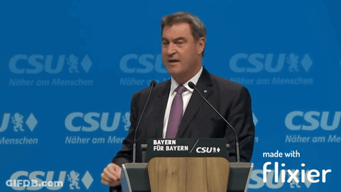 Man Giving Speech At Podium Saying Bayern GIF