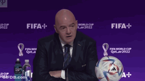 Man Giving Speech Beside Soccer Ball Saying Gay GIF