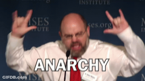 Man Giving Speech With Anarchy Behind GIF