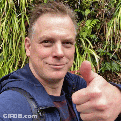 Man Giving Thumbs Up In Front Of Plant Wall GIF