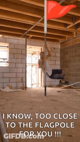 Man Hanging From Pole With Red Flag GIF