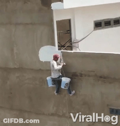 Man Hanging From Rope Painting Wall With Paint Buckets GIF