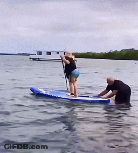 Man Helping Woman On Paddle Board GIF