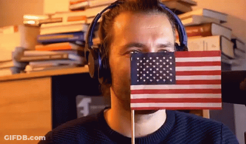 Man Hiding Behind Small American Flag With Headphones GIF