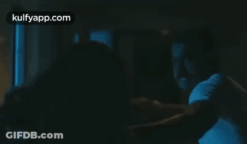 Man Holding Another Man In Dark Room GIF