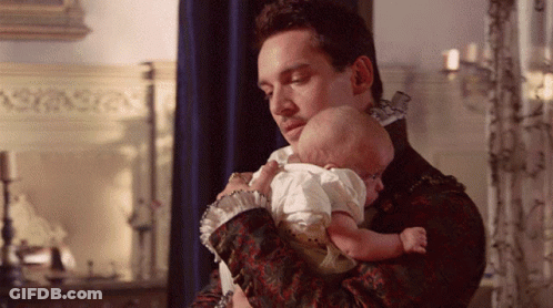 Man Holding Baby In Front Of Candles GIF