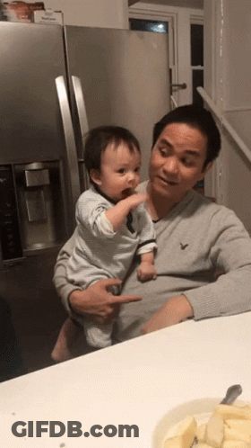 Man Holding Baby In Front Of Fridge GIF
