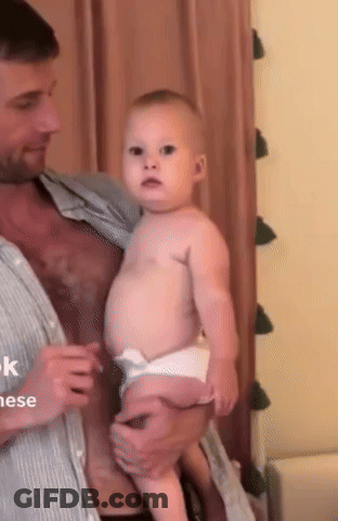 Man Holding Baby Looking At Camera GIF