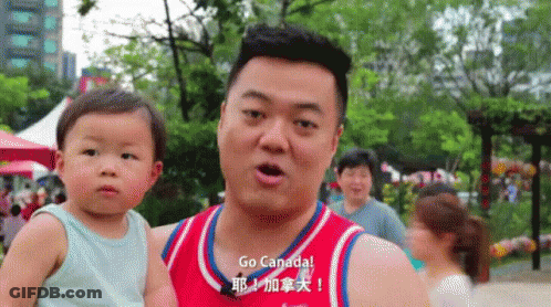 Man Holding Baby With Go Canada Shirt GIF