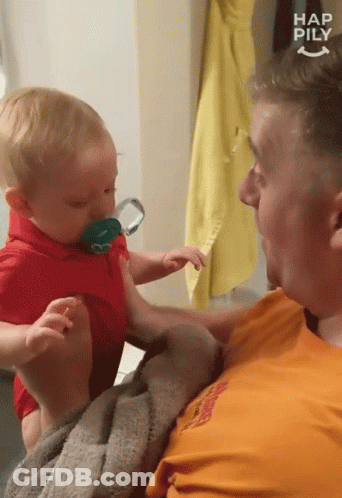 Man Holding Baby With Pacifier Saying Happily GIF