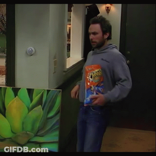 Man Holding Bag Of Cheetos In Front Of Plant Painting GIF