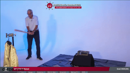 Man Holding Bat In Front Of Plastic Crown Contest Screen GIF