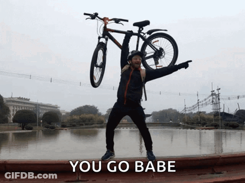Man Holding Bicycle Overhead Saying You Go Babe GIF