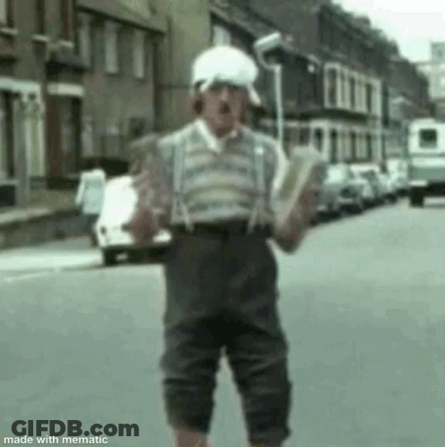 Man Holding Book In Street Wearing Suspenders GIF