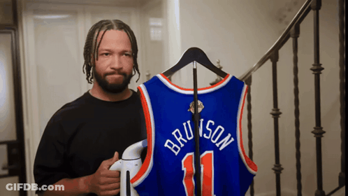 Man Holding Bruins Jersey On Hanger GIF
