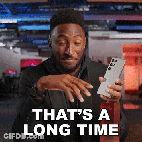 Man Holding Cell Phone Saying That's A Long Time GIF