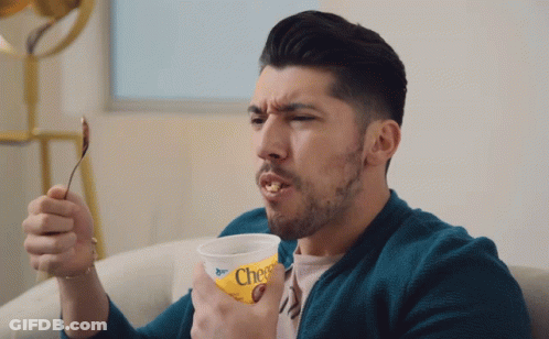 Man Holding Cheerios Cup With Spoon In Mouth GIF