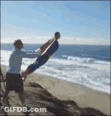 Man Holding Child In Air On Beach GIF