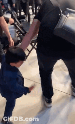 Man Holding Child's Hand Walking Down Hallway GIF
