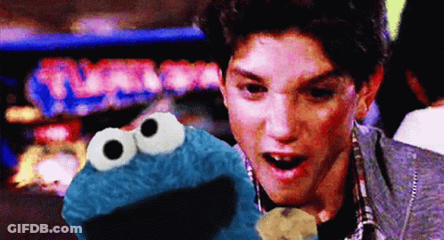 Man Holding Cookie Monster In Front Of Turbo Pinball Machine GIF