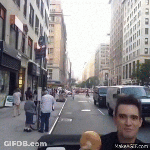 Man Holding Donut On City Street GIF