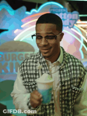Man Holding Drink In Front Of Burger King Neon Sign GIF