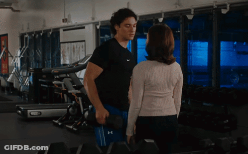 Man Holding Dumbbell Next To Woman GIF